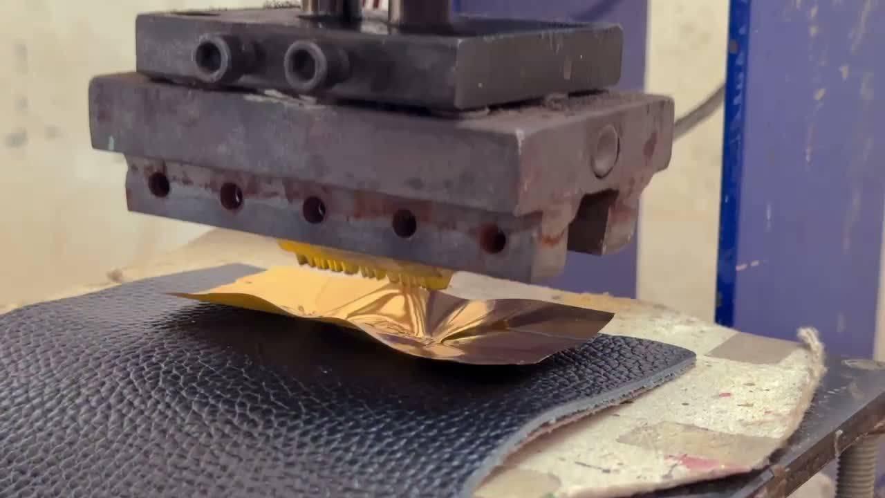 A close view of hot-foil work on a leather component in the atelier