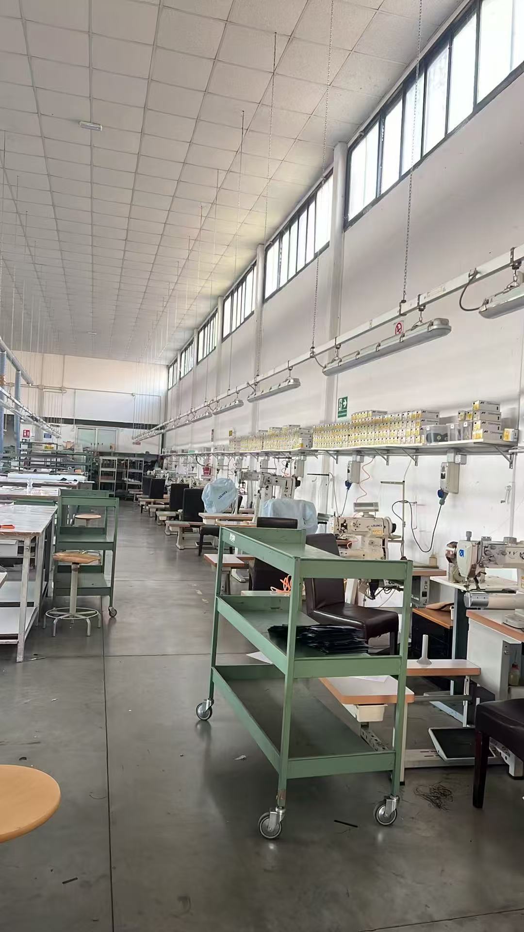 The FRAYDA production floor with industrial sewing stations, worktables and material trolleys near Florence